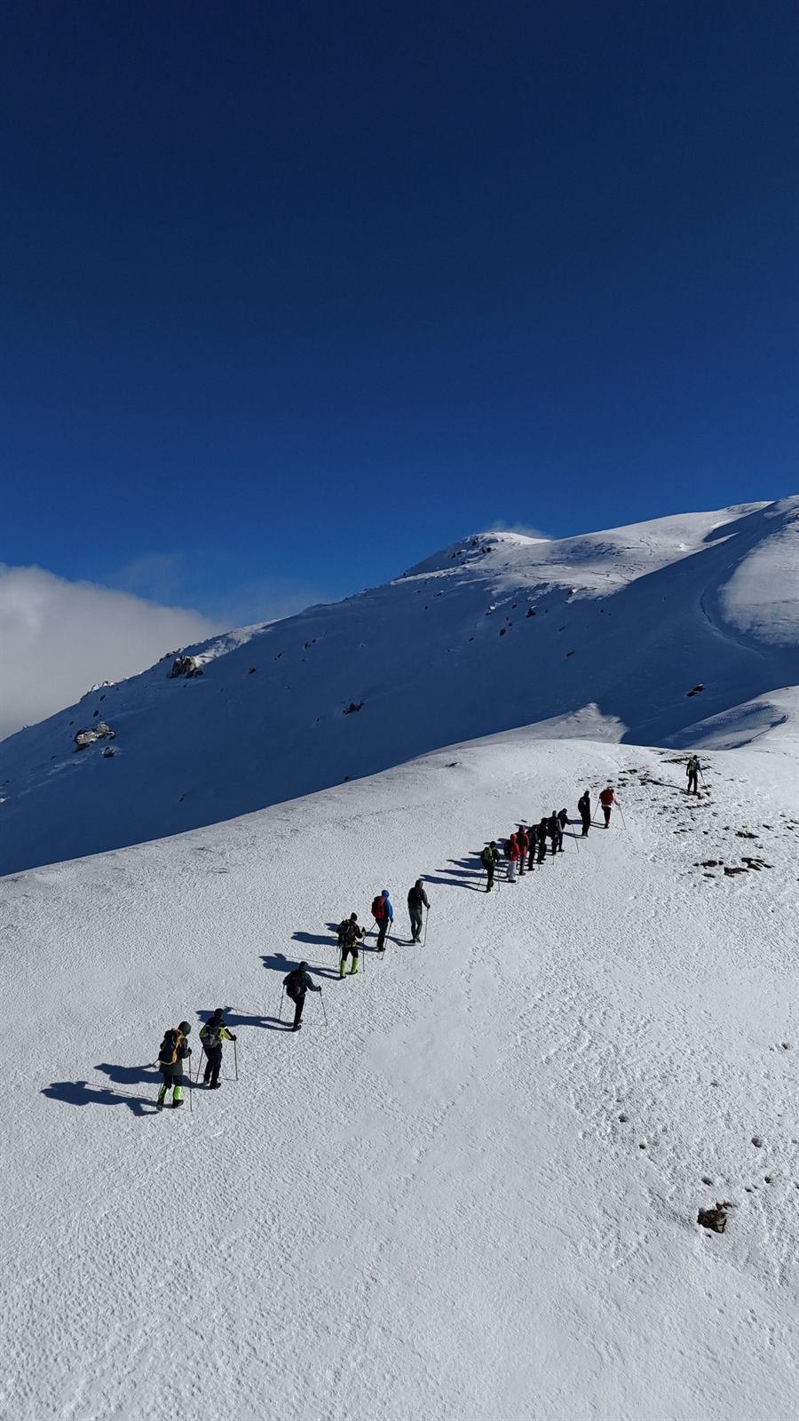 Progresión de un equipo en fila sobre una ladera de nieve en montaña invernal — Skadi