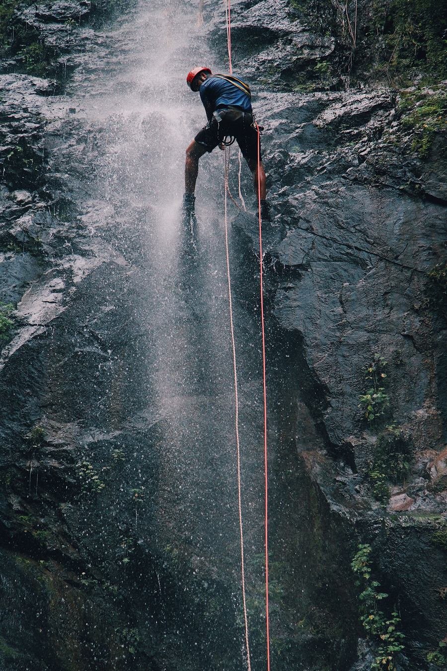 Técnico descendiendo en rápel por una cascada en un barranco — Skadi
